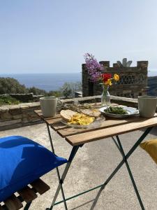 a picnic table with a plate of food on it at Andros Vineyard house with sea view in Sinétion