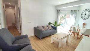 salon z kanapą i stołem w obiekcie EA! Las Arenas Family - Alojamientos La Torre w mieście Torre del Mar