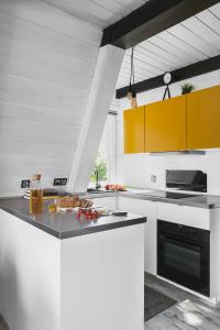 a kitchen with white cabinets and a black oven at Aspen - Domek w Korbielowie in Korbielów