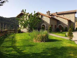 an old stone house with a green yard at Condado de San Martín in Boltaña