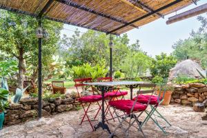 a patio table and chairs under a pergola at Casa en olivera a 3 km de la costa in Perelló