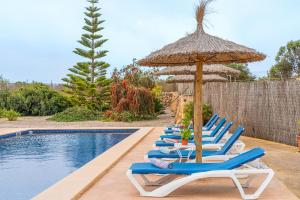 a row of lounge chairs and an umbrella next to a pool at Camp de Sitjar Sa Punta in Ses Salines