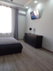 um quarto com uma cama, uma cómoda e uma janela em Апартаменты в центре города em Chernivtsi