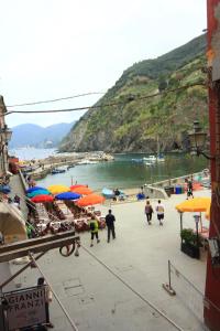 a group of people walking on a beach with umbrellas at VERNAZZA CENTRALE in Vernazza +8 photos