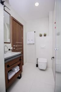 a white bathroom with a sink and a toilet at Hotel Bograd - Apartments & Lounge Station in Struga