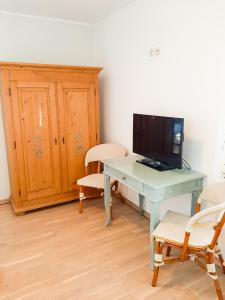 een kamer met een bureau, een televisie en stoelen bij Kornmühle Doppelzimmer Mühlenstein in Mellenthin