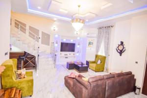a living room with a couch and a staircase at Executive 4 bedroom house in Lagos