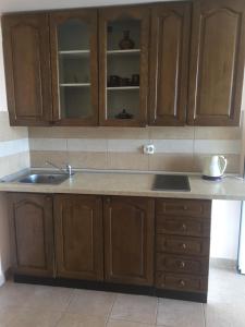 a kitchen with wooden cabinets and a sink at Вилла Natalia in Tivat +102 photos