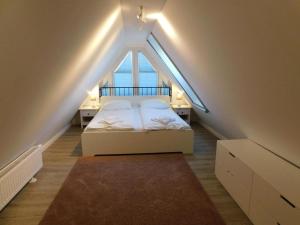 a bedroom with a bed with a large window at Darßer Strandgut - Haus Ahrenshooper Holz in Ahrenshoop