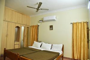 a bedroom with a bed and a ceiling fan at jayaram Home Palace Chittoor in Chittoor