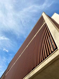 wysoki budynek z brązowym dachem na górze w obiekcie S´Estancia Suites w mieście Es Mercadal
