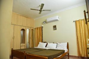 a bedroom with a bed and a ceiling fan at jayaram Home in Chittoor