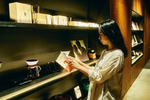 a woman is looking at a book on a shelf at 41 PIECES Sapporo in Sapporo +24 photos