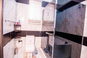 ein Badezimmer mit Toilette und Glasdusche in der Unterkunft Executive 4 bedroom house in Lagos
