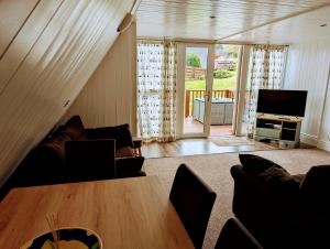 a living room with a couch and a table at Coastal Chalet - Sleeps 6 - Pool - Parking in Kingsdown