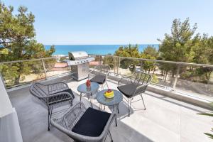 un patio con sedie e un grill sul balcone di ANASTASIOS HOUSE STEGNA - UP FLOOR a Archangelos