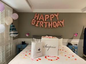 a birthday room with a bed with a happy birthday sign at 朵兒dor韓國汗蒸幕 동대문점 商務旅店 in Taipei