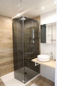 a glass shower in a bathroom with a sink at Les Alcyons in Le Lavandou