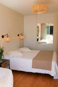 a bedroom with two beds and a large mirror at Les Alcyons in Le Lavandou