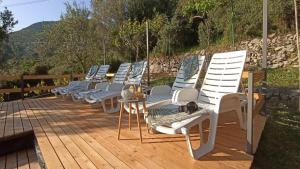 une rangée de chaises assises sur une terrasse en bois dans l'établissement Apartments Baldo, à Slano