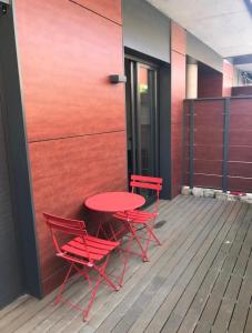 two red chairs and a table on a deck at Apartamento con encanto in Igualada