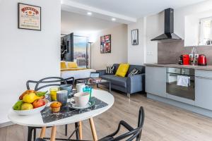 a kitchen and a living room with a table and chairs at Le 31-GregIMMO-Appart'Hôtel in Montbéliard