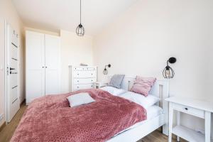 a white bedroom with a bed and a desk at Apartament 409 Natural Darłówko in Darłowo