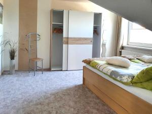 una camera con letto, scala e specchio di Ferienwohnung Reins a Neustadt in Holstein