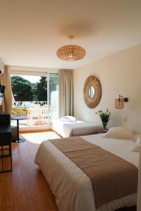 Habitación de hotel con 2 camas y espejo en Les Alcyons, en Le Lavandou