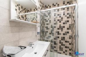a white bathroom with a sink and a shower at MODERN apartments WAVE near the AIRPORT in Velika Gorica