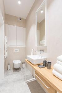 a bathroom with a sink and a toilet and a mirror at Gdynia Baltiq Plaza in Gdynia