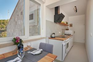 a small kitchen with a table and a window at Apartments Micika in Cavtat