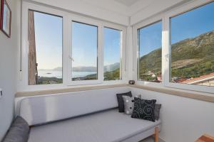 a room with a bench in front of windows at Apartments Micika in Cavtat