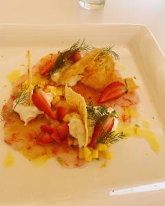 a white plate of food with vegetables and fruit at Ganimede Hotel in Sperlonga