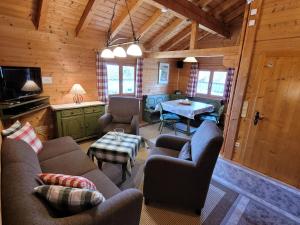 a living room with couches and a table in a cabin at Blockhäuser Stamsried in Stamsried