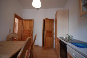 a kitchen with a wooden table and a sink at Pension am Dom in Schwerin