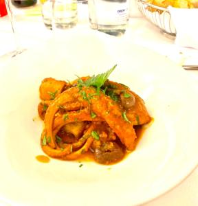 a white plate of food on a table at Ganimede Hotel in Sperlonga