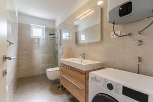 een badkamer met wastafel en wasmachine bij Best Sea View Apartment in Cres +22 foto's