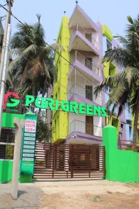 a yellow building with a sign in front of it at HOTEL PURI GREENS in Puri