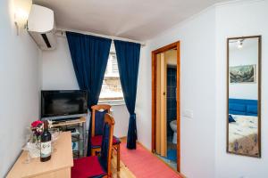 uma pequena sala de estar com televisão e mesa em Rooms Fausta Old Town em Dubrovnik