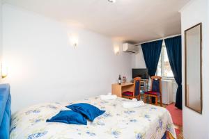um quarto com uma cama com almofadas azuis em Rooms Fausta Old Town em Dubrovnik