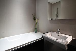a bathroom with a sink and a vase of flowers at Hotel The Designers Hongdae in Seoul