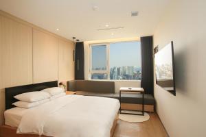 a bedroom with a bed and a large window at Hotel The Designers Hongdae in Seoul