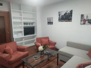 uma sala de estar com um sofá e duas cadeiras e uma mesa em Céntrico apartamento junto al casco histórico em Córdoba
