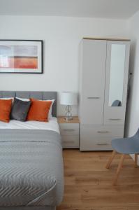 a bedroom with a bed with orange pillows and a mirror at Exclusive Ensuite Double Room in London