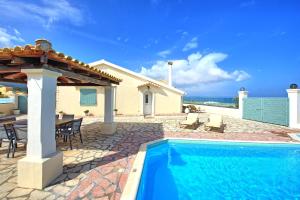 a villa with a swimming pool and a house at Beach Villa Athanasia - villa with private pool on the beach by PosarelliVillas in Acharavi