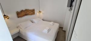 
a bed room with a white bedspread and pillows at Eternal Town in Mikonos
