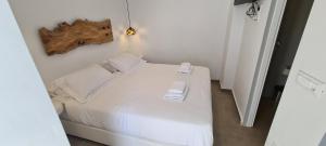 
a bed room with a white bedspread and pillows at Eternal Town in Mikonos
