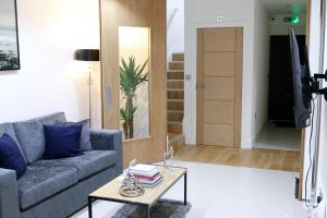 a living room with a couch and a table at Exclusive Ensuite Double Room in London