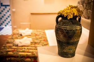 a vase with yellow flowers in it sitting on a table at CASA FRANCY in Castelmola